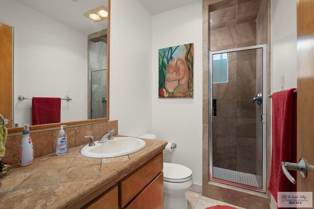 bathroom featuring walk in shower, tile patterned flooring, vanity, and toilet