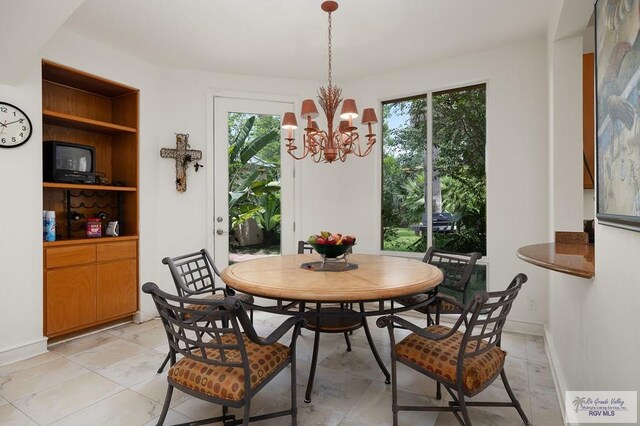 dining room with plenty of natural light, built in features, and a chandelier