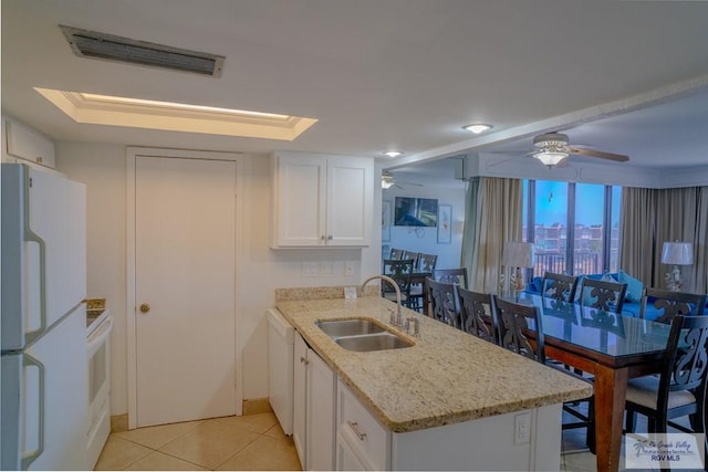 kitchen featuring kitchen peninsula, white appliances, sink, white cabinets, and light tile patterned flooring