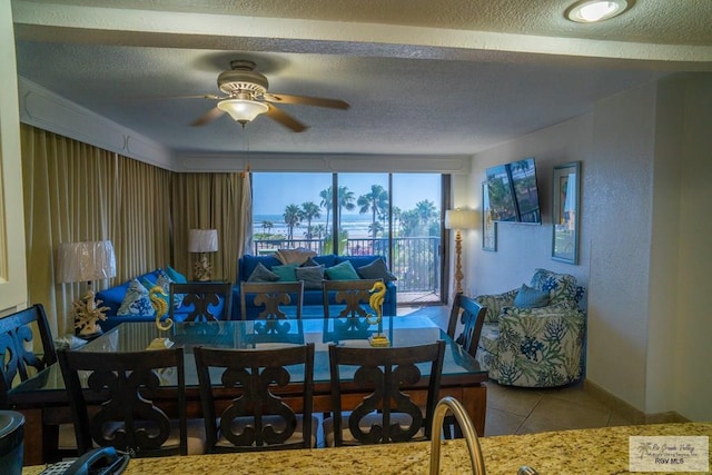 tiled dining area featuring ceiling fan and a textured ceiling