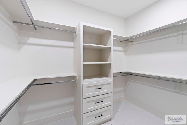 walk in closet featuring marble finish floor
