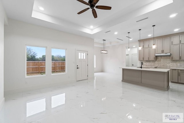 kitchen with gray cabinetry, recessed lighting, marble finish floor, and under cabinet range hood