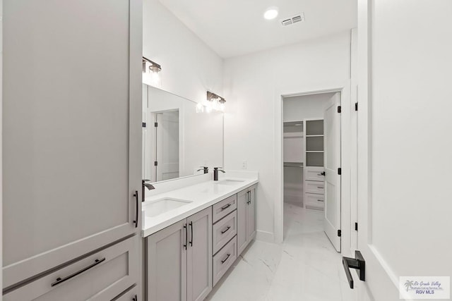 full bath featuring visible vents, a sink, double vanity, and marble finish floor