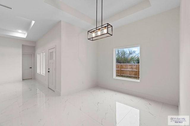 unfurnished room featuring recessed lighting, marble finish floor, baseboards, and a tray ceiling