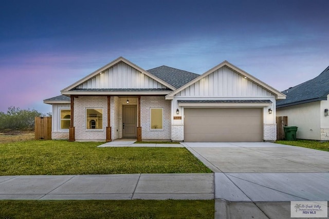 view of front of property featuring driveway, board and batten siding, a yard, brick siding, and a garage