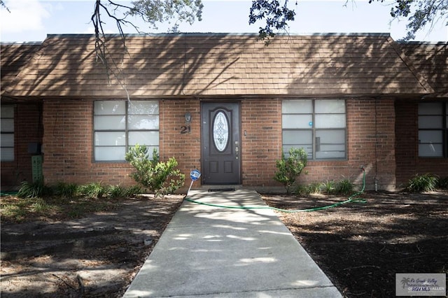 304 Hidden Valley Dr, Weslaco, TX 78596 - doorway to property featuring brick siding and roof with shingles