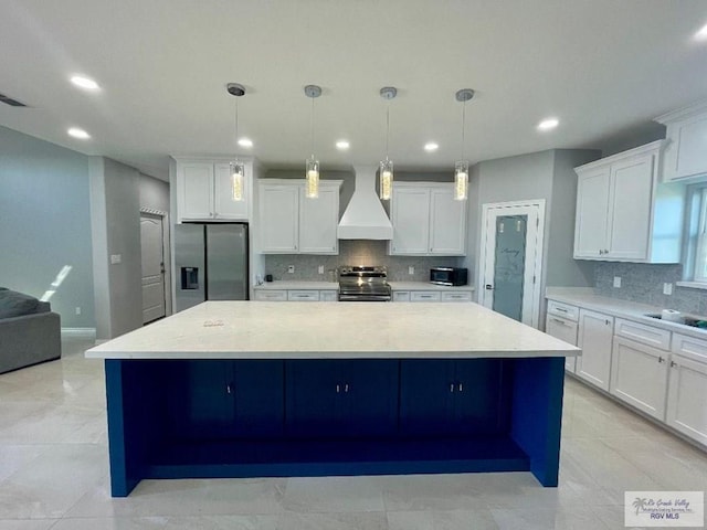 kitchen with pendant lighting, custom exhaust hood, stainless steel appliances, and a large island