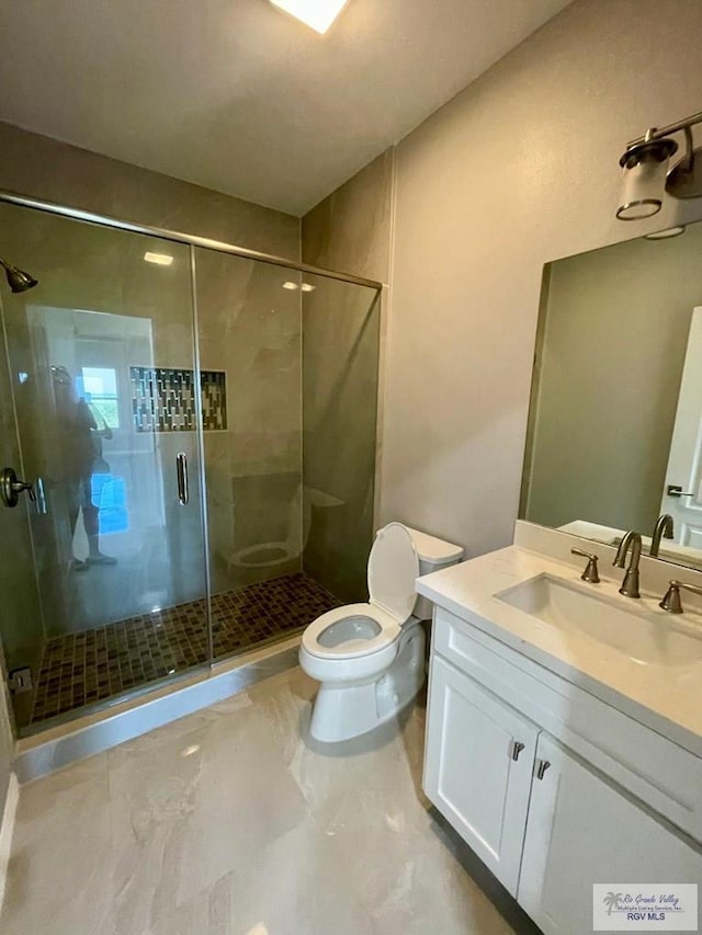 bathroom featuring vanity, an enclosed shower, and toilet