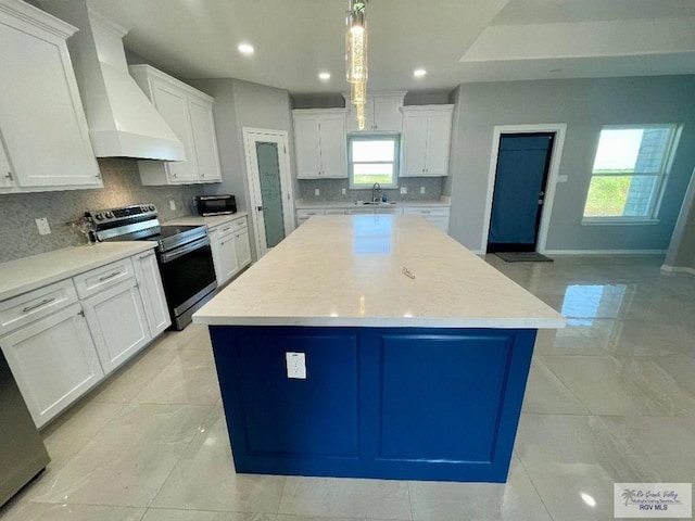 kitchen with a center island, stainless steel range with electric stovetop, a healthy amount of sunlight, and custom exhaust hood