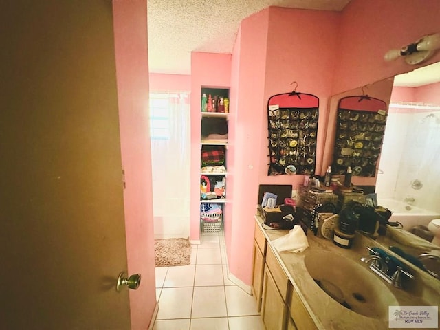 bathroom with tile patterned flooring, vanity, a textured ceiling, and bathtub / shower combination