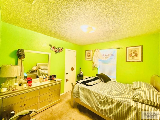 bedroom featuring light colored carpet and a textured ceiling