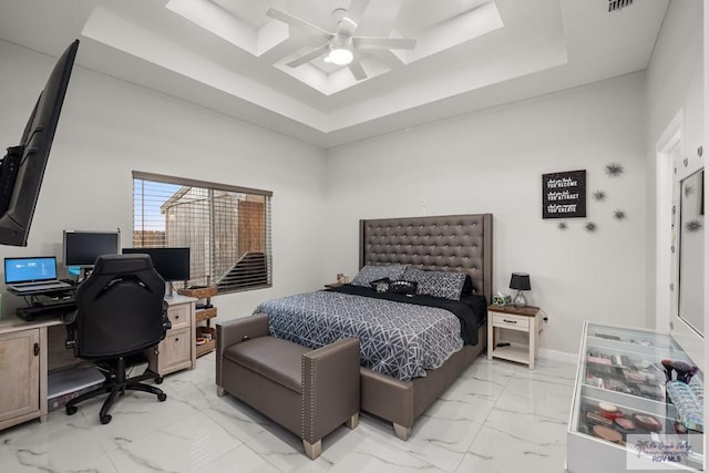 bedroom with ceiling fan and a raised ceiling