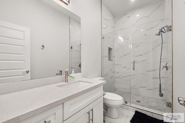 bathroom featuring vanity, toilet, and a shower with shower door