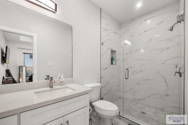 bathroom with vanity, an enclosed shower, and toilet