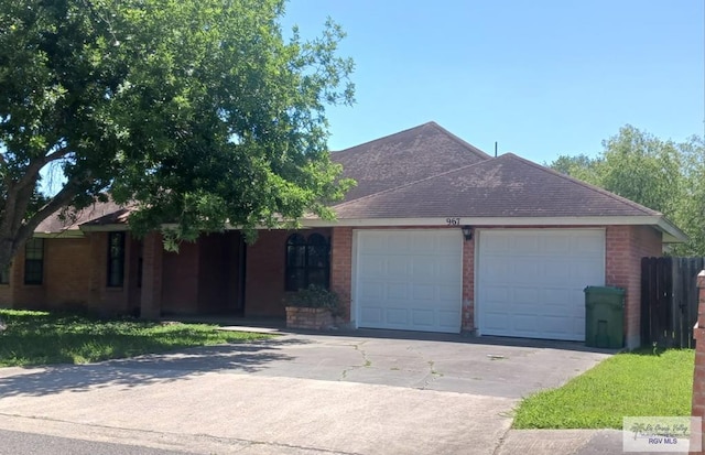 ranch-style home featuring brick siding, an attached garage, driveway, and roof with shingles