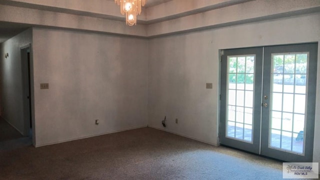 unfurnished room featuring french doors and carpet flooring