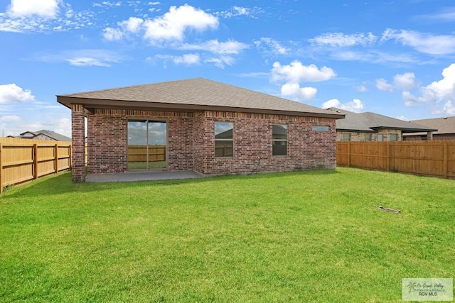 back of property featuring a yard and a patio