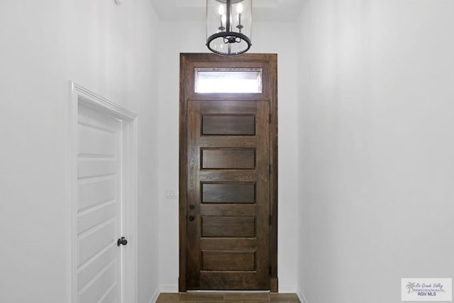 doorway to outside featuring light tile patterned floors and a chandelier