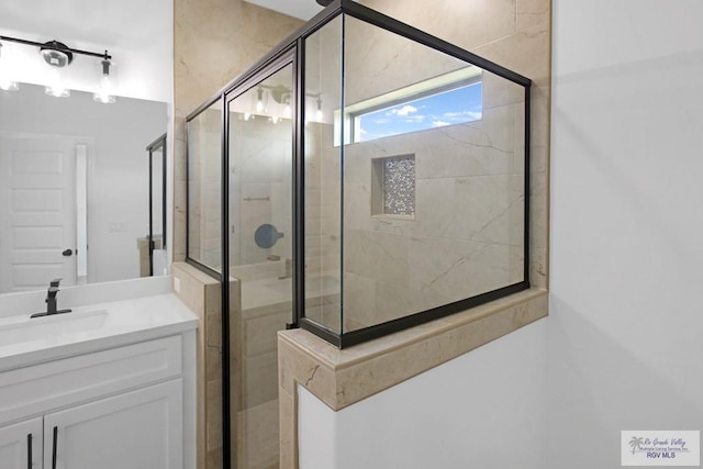 bathroom with vanity and a shower with door