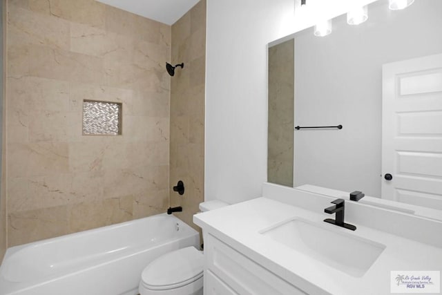 full bathroom featuring vanity, tiled shower / bath combo, and toilet