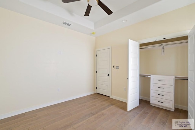 32773 Jorge St, Los Fresnos, TX 78566 - unfurnished bedroom with a raised ceiling, a closet, baseboards, light wood-style flooring, and ceiling fan