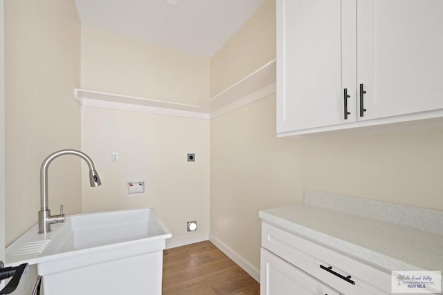 32773 Jorge St, Los Fresnos, TX 78566 - laundry area featuring wood finished floors, a sink, baseboards, electric dryer hookup, and washer hookup