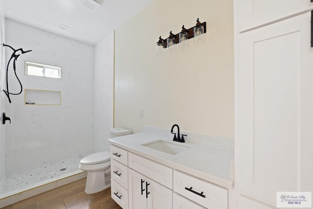 32773 Jorge St, Los Fresnos, TX 78566 - full bathroom with toilet, vanity, wood finished floors, and a marble finish shower
