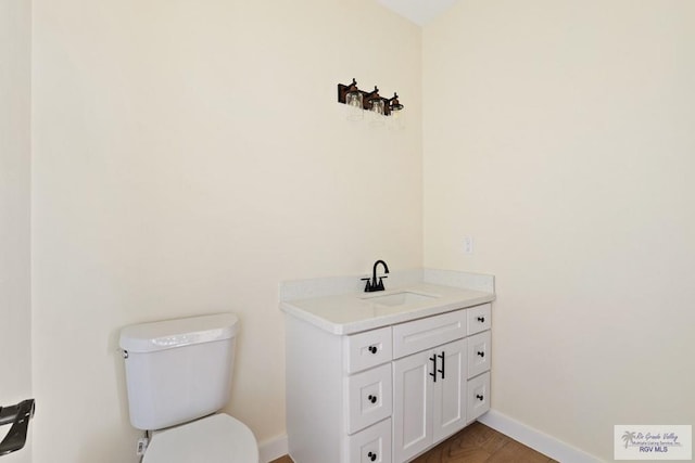 32773 Jorge St, Los Fresnos, TX 78566 - bathroom featuring toilet, vanity, wood finished floors, and baseboards