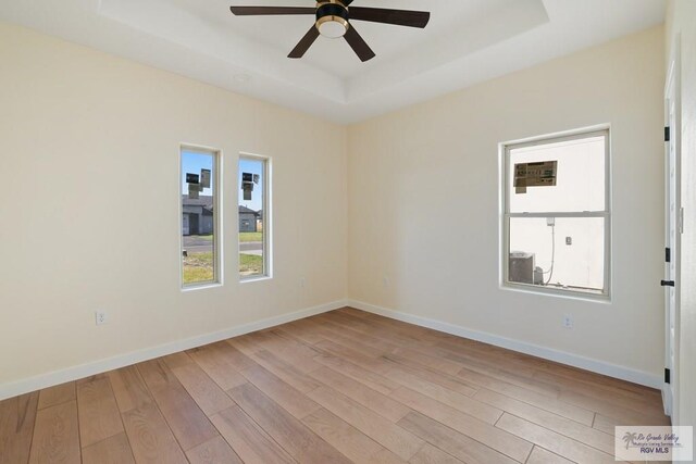 32773 Jorge St, Los Fresnos, TX 78566 - empty room featuring baseboards, a ceiling fan, wood finished floors, and a raised ceiling