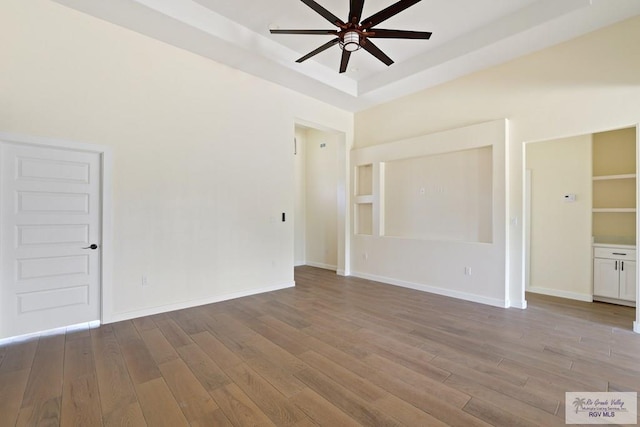 32773 Jorge St, Los Fresnos, TX 78566 - unfurnished room featuring baseboards, a ceiling fan, wood finished floors, and a tray ceiling