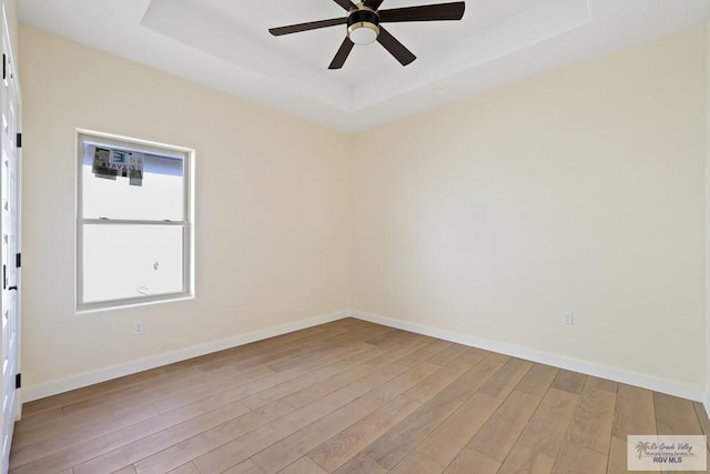 32773 Jorge St, Los Fresnos, TX 78566 - spare room featuring baseboards, a ceiling fan, light wood finished floors, and a raised ceiling