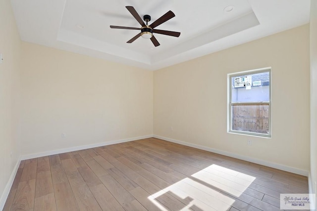 32773 Jorge St, Los Fresnos, TX 78566 - unfurnished room with a raised ceiling, light wood-style flooring, a ceiling fan, and baseboards