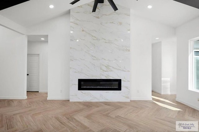 unfurnished living room with high vaulted ceiling, recessed lighting, a fireplace, a ceiling fan, and baseboards