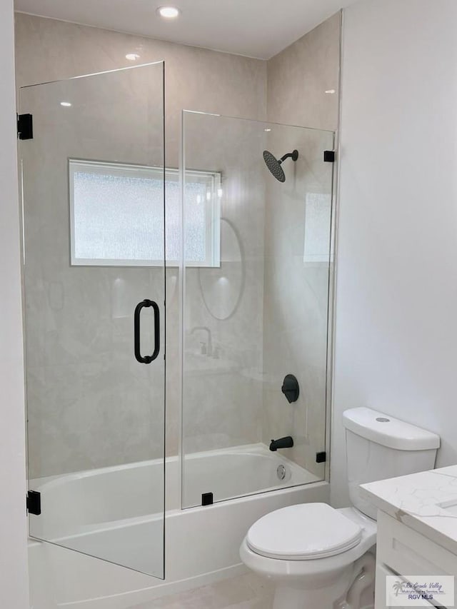 full bathroom with toilet, vanity, and shower / bath combination with glass door