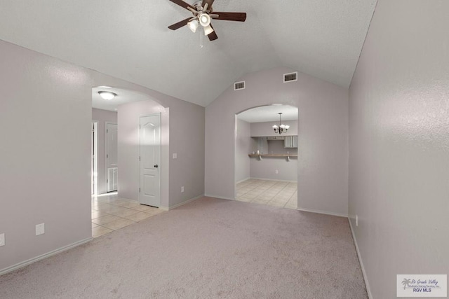 carpeted spare room with ceiling fan and vaulted ceiling