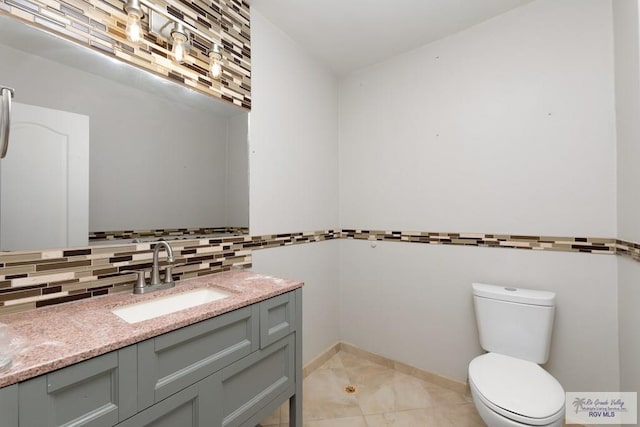 bathroom with vanity, tasteful backsplash, and toilet