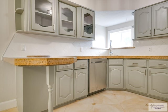 kitchen with gray cabinets, decorative backsplash, and dishwasher