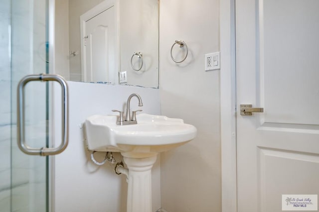 bathroom featuring an enclosed shower and sink