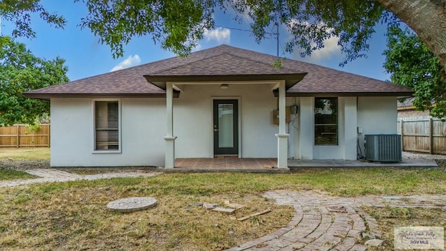 rear view of house featuring a yard and central AC