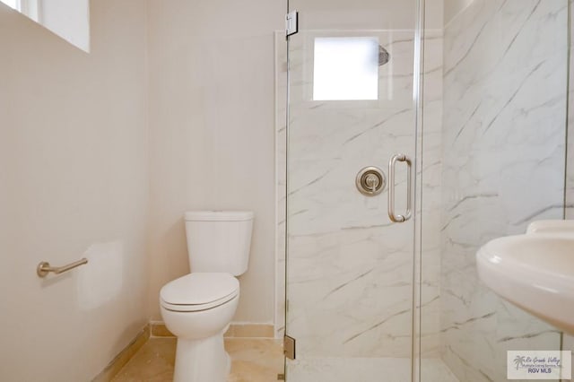 bathroom featuring tile patterned floors, toilet, a shower with door, and sink