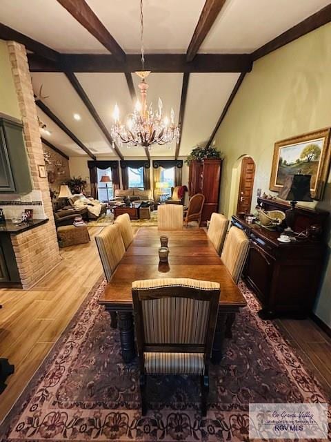 dining area with a notable chandelier, beam ceiling, decorative columns, and dark hardwood / wood-style floors