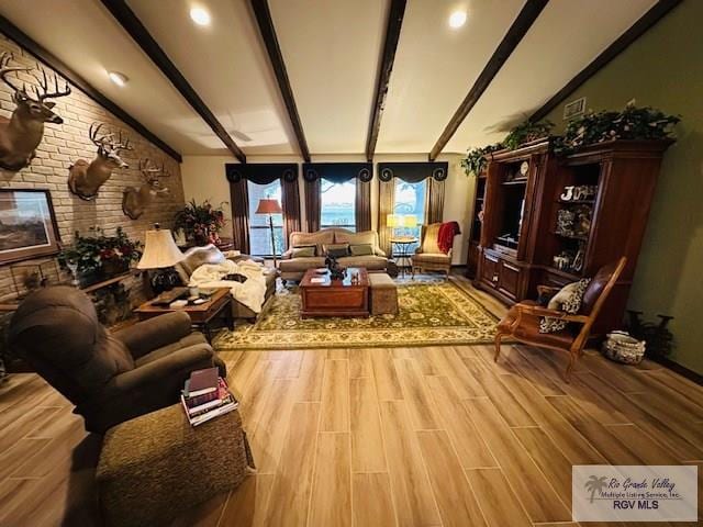 sitting room with brick wall, beam ceiling, and light hardwood / wood-style flooring