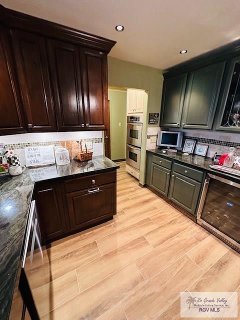 kitchen with dark stone countertops, double oven, backsplash, and dishwashing machine