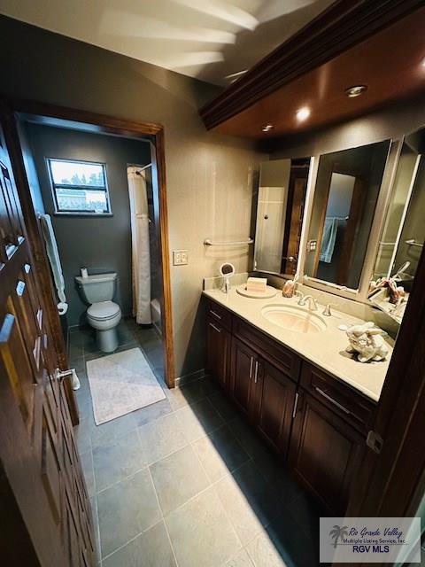 bathroom with a shower with curtain, vanity, toilet, and tile patterned flooring