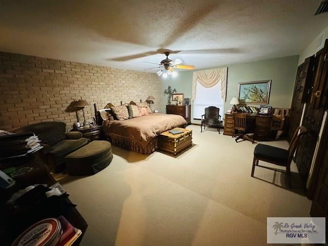 carpeted bedroom with ceiling fan and a textured ceiling