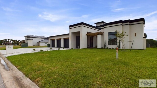 60 Jacklyn St, Rancho Viejo, TX 78575 - view of front facade with a front yard and a garage