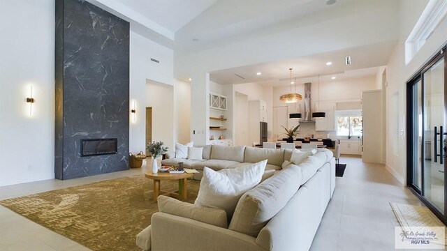 60 Jacklyn St, Rancho Viejo, TX 78575 - tiled living room featuring built in features, high vaulted ceiling, and a premium fireplace