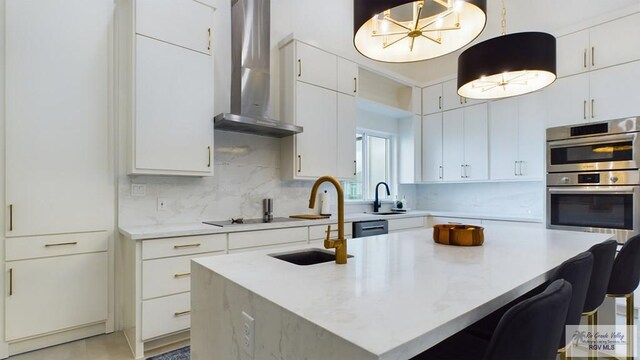 60 Jacklyn St, Rancho Viejo, TX 78575 - kitchen with hanging light fixtures, wall chimney range hood, tasteful backsplash, double oven, and white cabinets