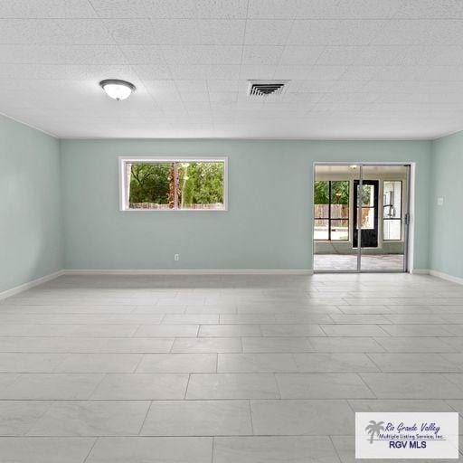 tiled empty room with a wealth of natural light