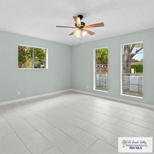 spare room with ceiling fan and a healthy amount of sunlight